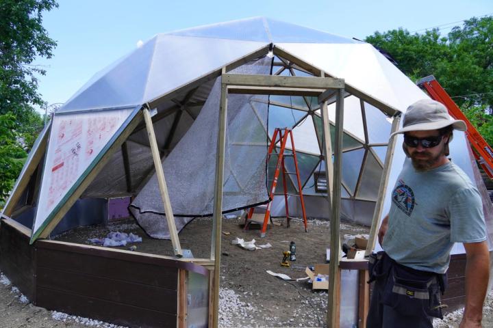 Growing Spaces supervisor building a greenhouse door frame