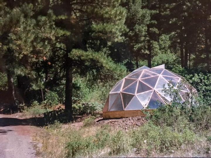 Thirty-two year old 22 foot diameter growing dome greenhouse nestled in pines and oak brush
