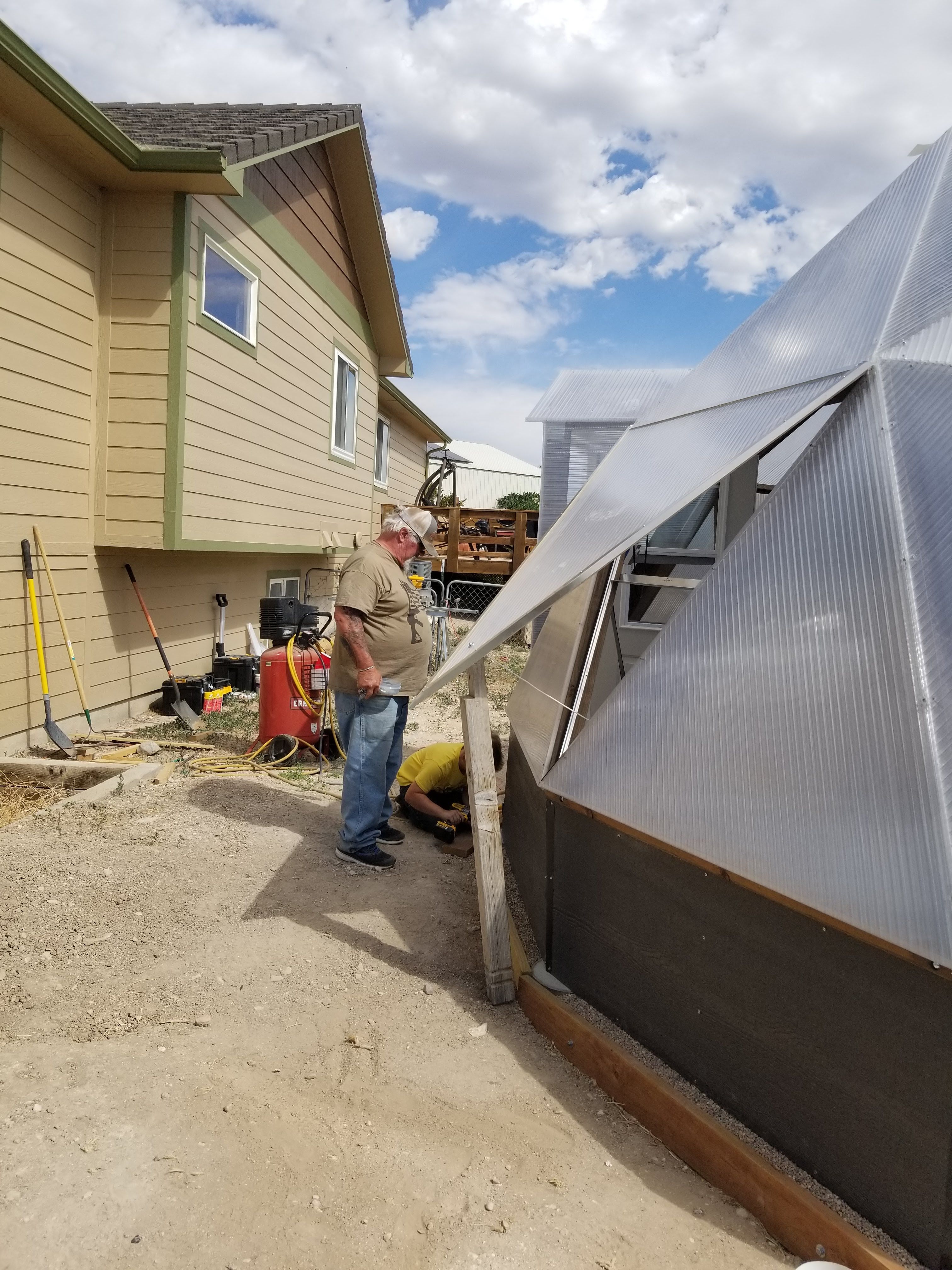 Person working beside a partially assembled Growing Dome on the Colorado High Plains