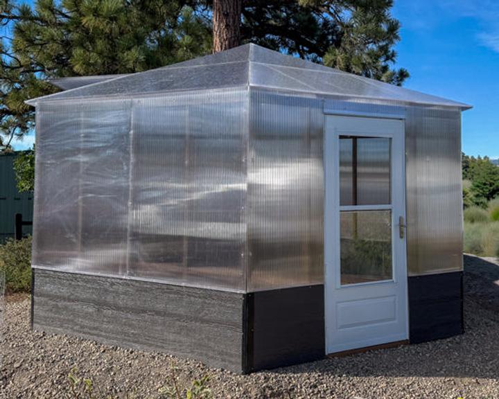 growzebo hexagonal greenhouse on Growing Spaces campus near evergreen tree