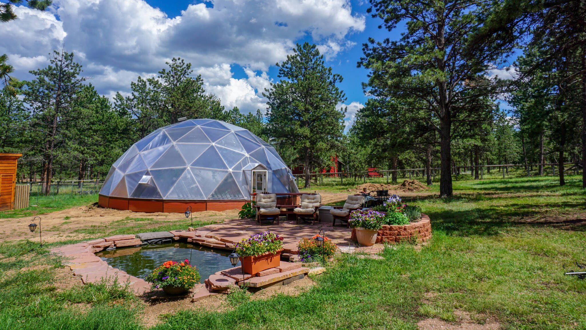 outdoor patio and pond in front of greenhouse