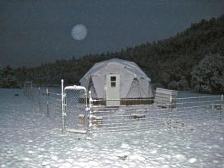 New Mexico Greenhouse covered in snow under a full moon