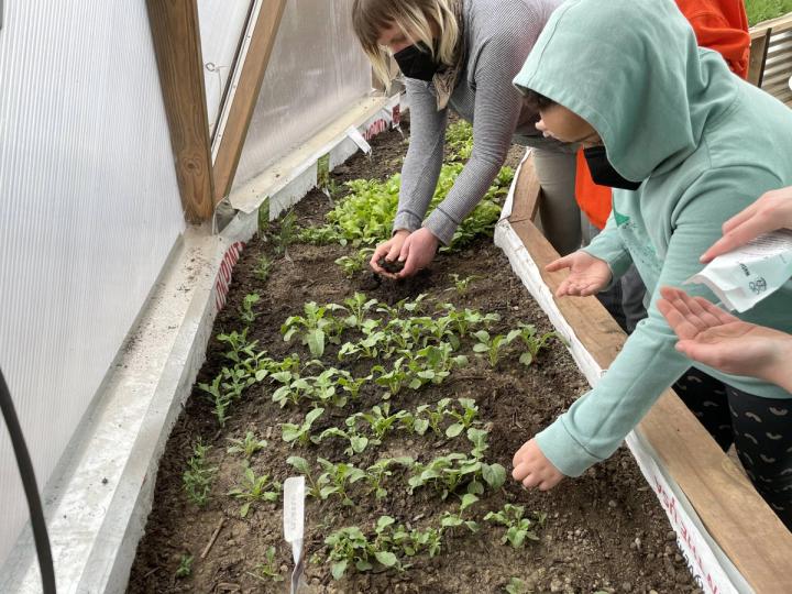 Child and parent planting seeds in a Growing Dome greenhouse