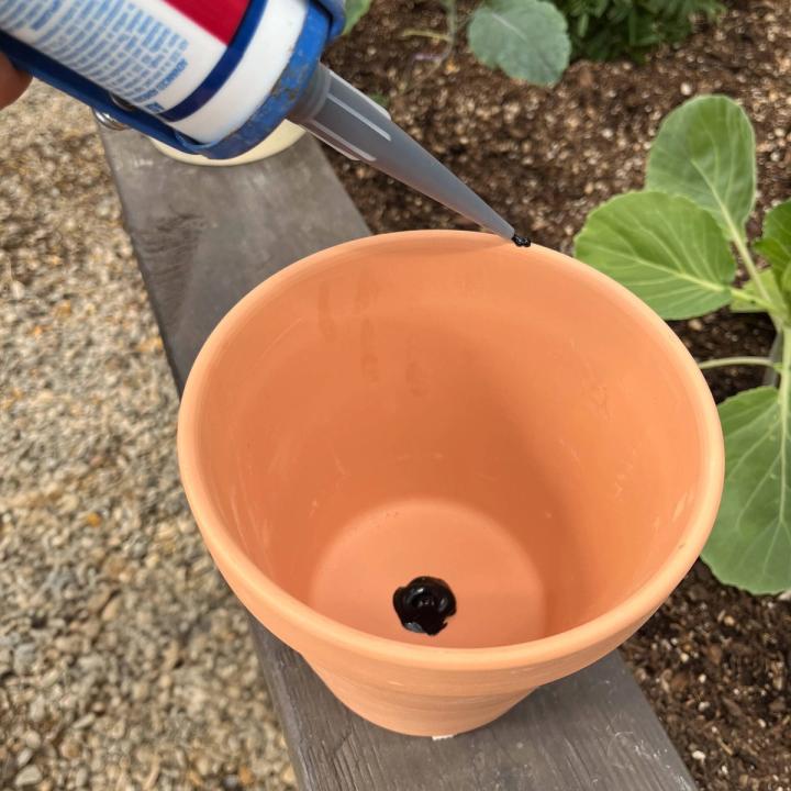 Terracotta pot with waterproof silicone blocking the drainage hole.