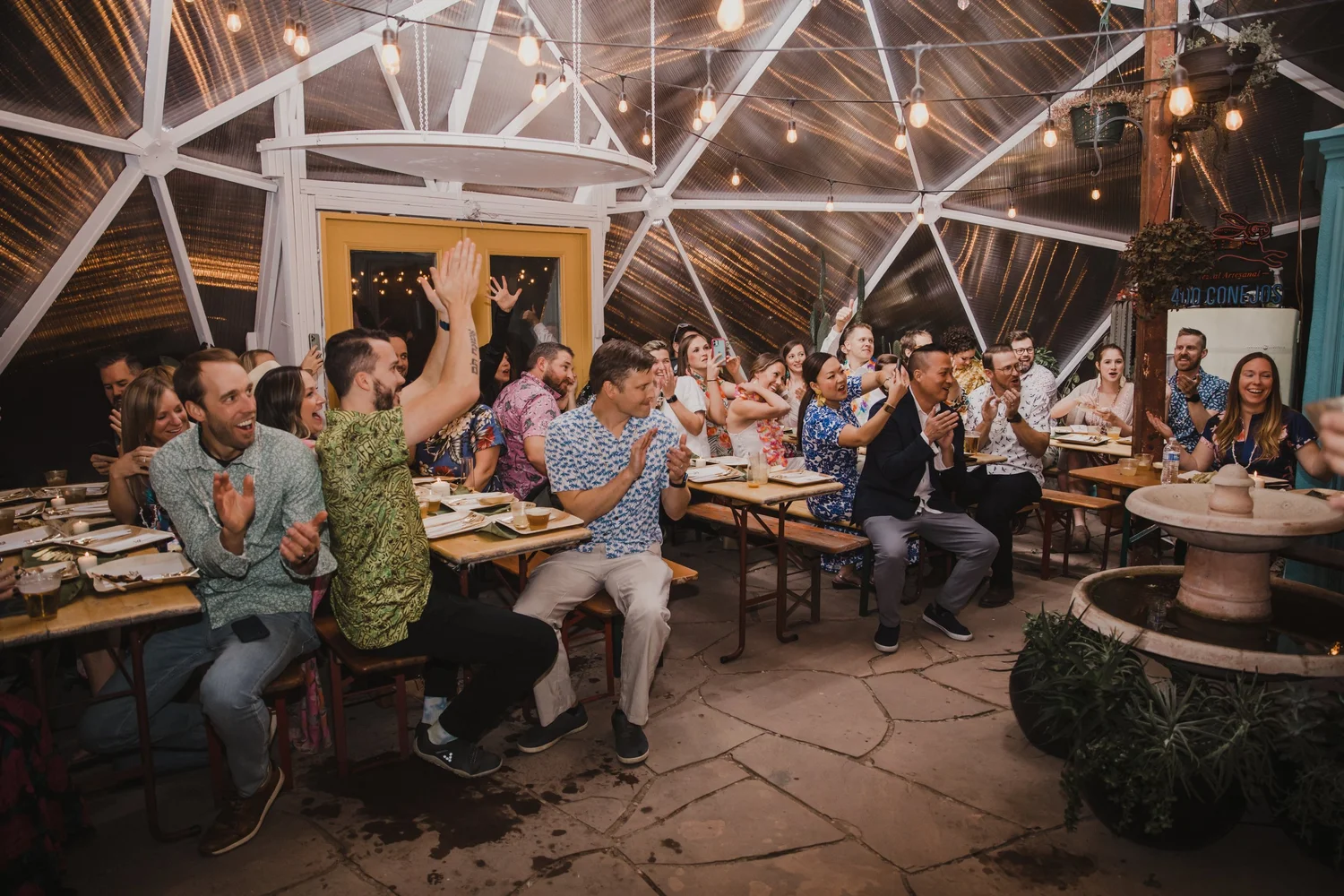 Crowd clapping while seated at tables inside a Growing Dome