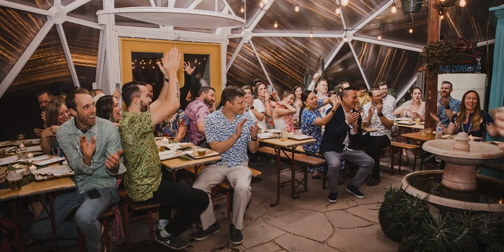 Crowd clapping while seated at tables inside a Growing Dome