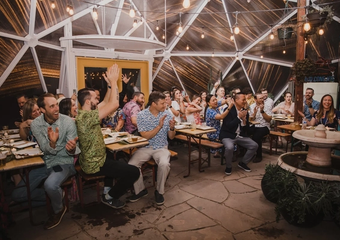 Crowd clapping while seated at tables inside a Growing Dome