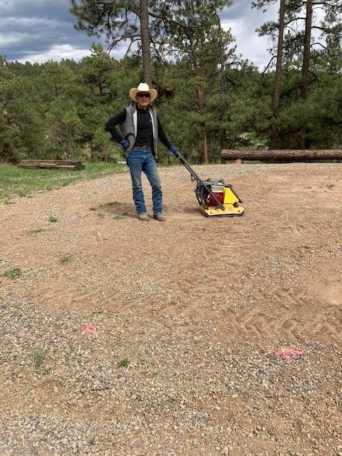 Radel McKibben preparing and flattening the ground with a machine to get ready for their greenhouse