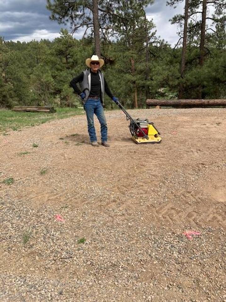 Radel McKibben preparing and flattening the ground with a machine to get ready for their greenhouse