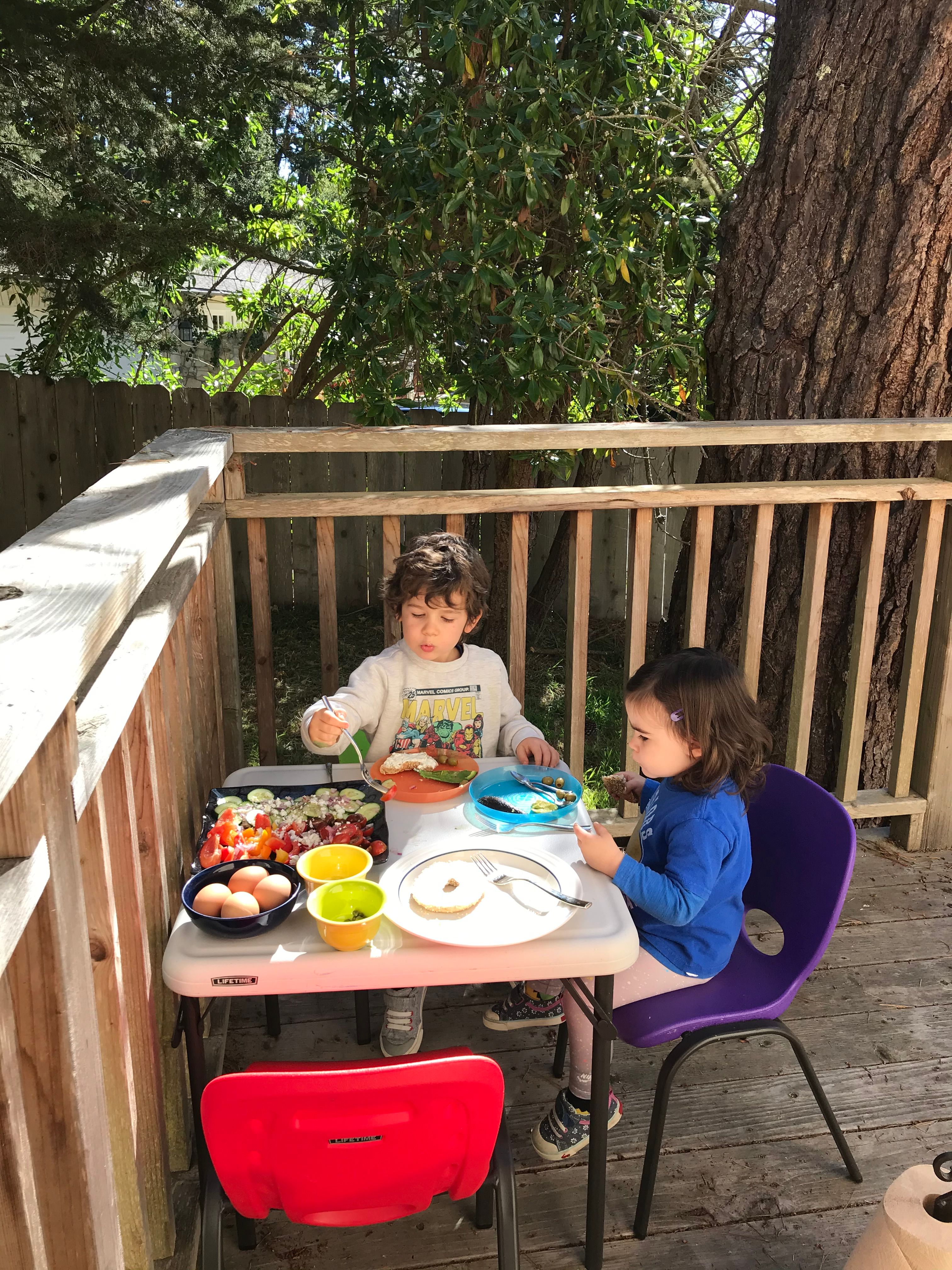 children eating carpaccio-style salad on a deck