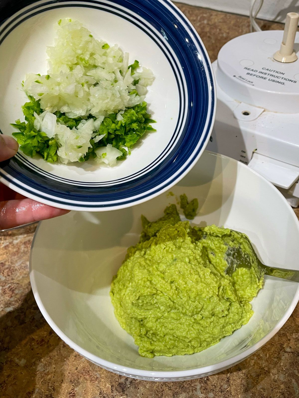 adding jalapenos and onions to guacamole