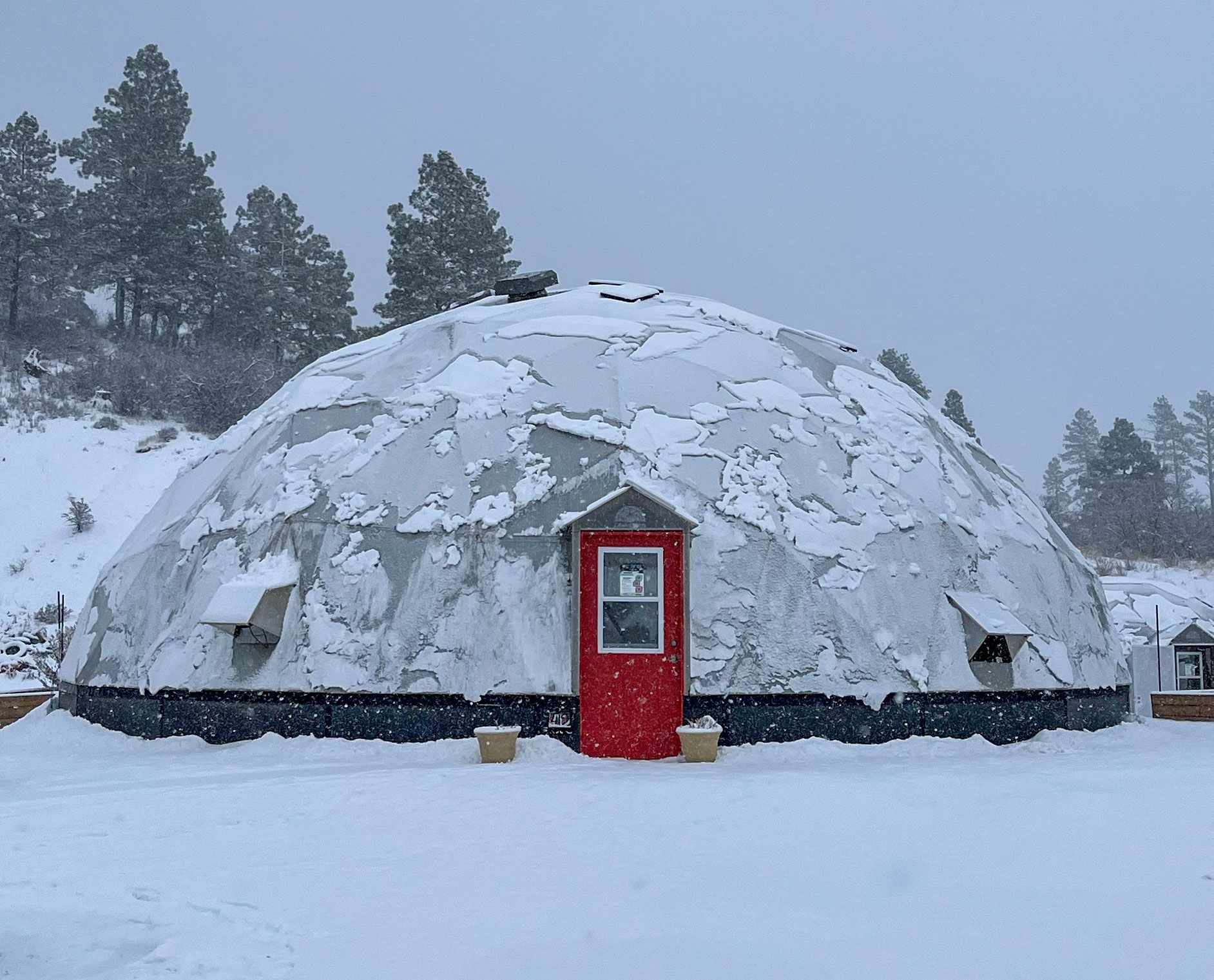 Snow sliding off geodesic greenhouse in winter
