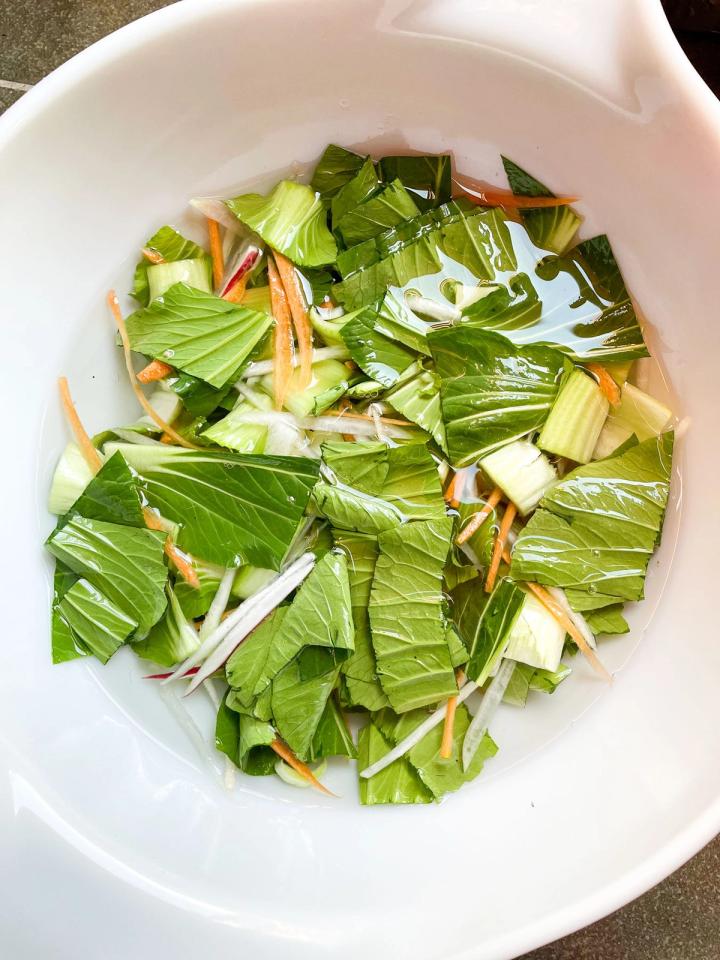 mixing bowl of chopped vegetables covered in salt water