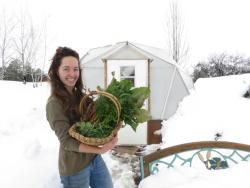 gardener holding a basket of fresh produce from a greenhouse during winter