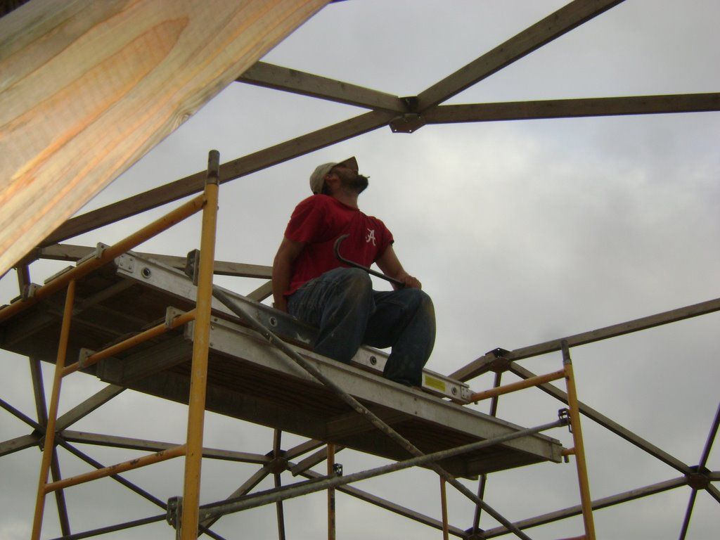 Worker evaluates greenhouse frame connector