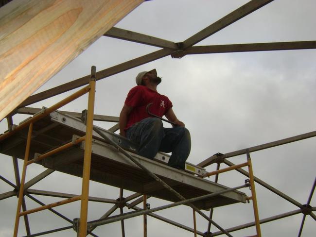 Worker evaluates greenhouse frame connector