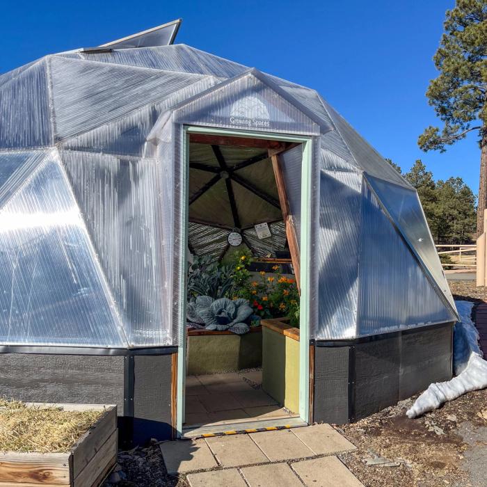 26 foot diameter growing dome greenhouse with door open during winter