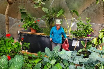 gardener peacefully enjoying her growing dome greenhouse
