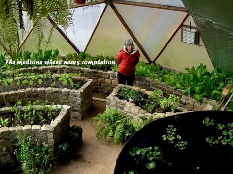 person standing inside the 33' dome between rock raised beds