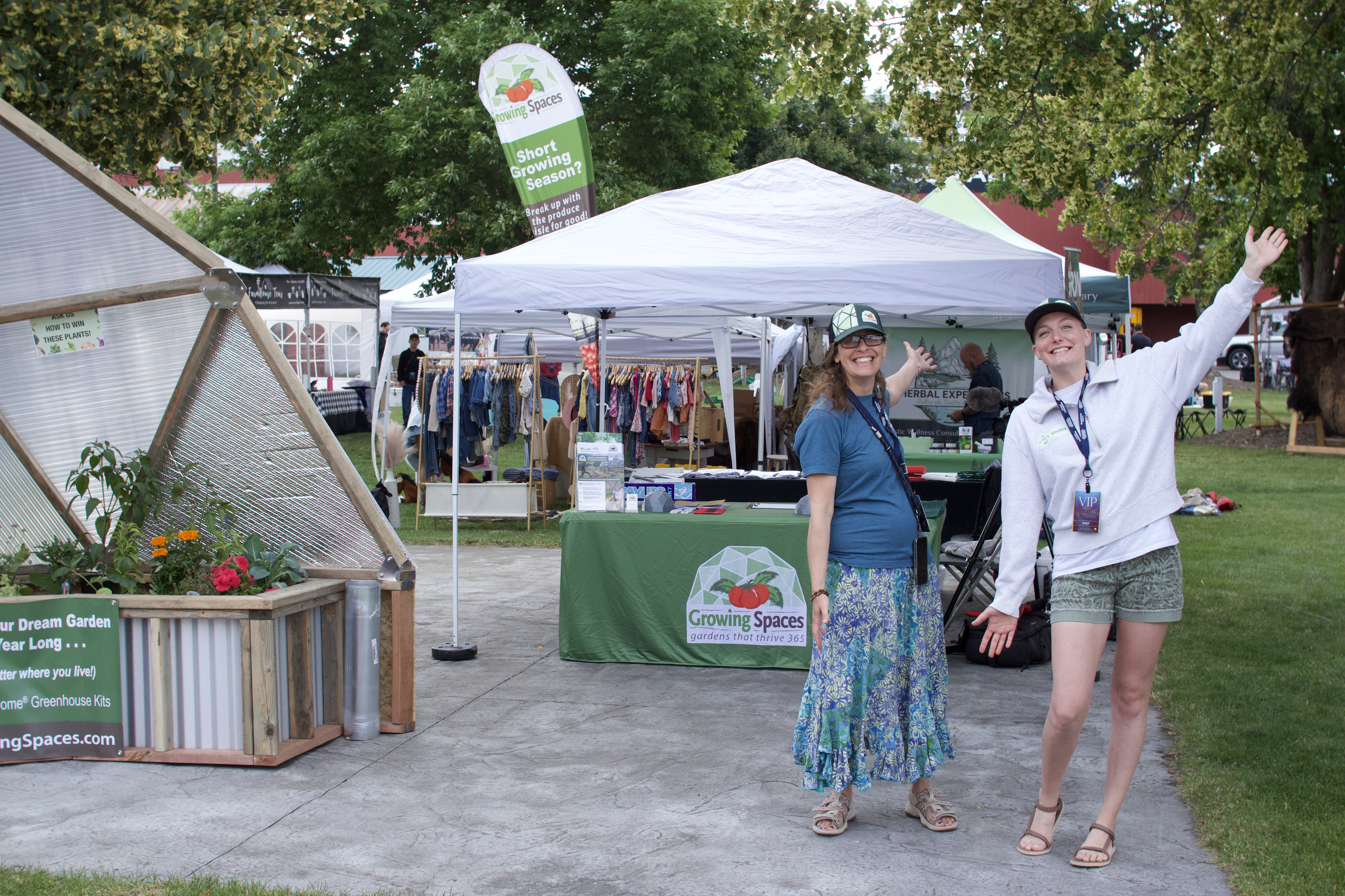 Two ladies standing in front of a brand booth at an event