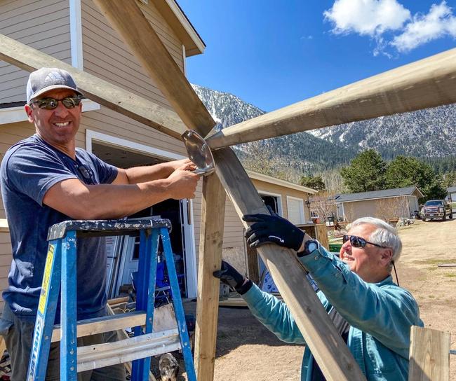 two men constructing the framework of a greenhouse