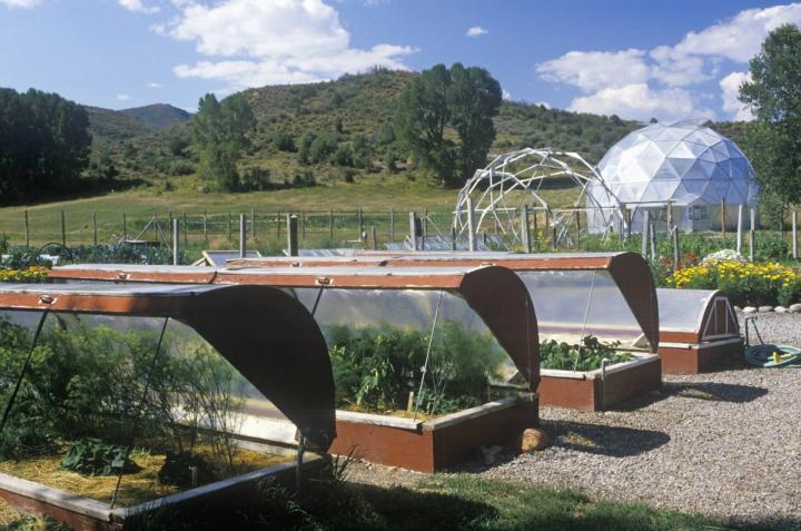 Environmental research biodome at the Windstar Foundation in Aspen, Colorado. Large dome in the background with smaller, open cold frames in the foreground.