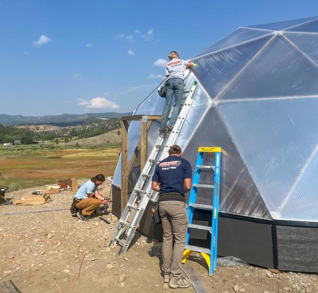 installation crew working outside of geodesic greenhouse