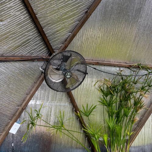 Horizontal airflow fan in a greenhouse with reflective insulation behind it