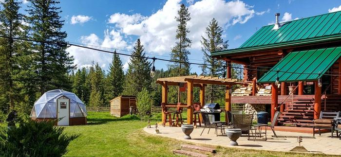 15' growing dome greenhouse in a yard next to the house with a large patio