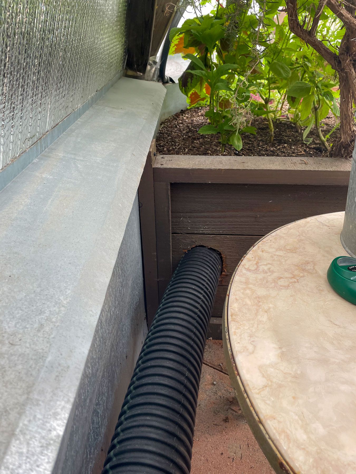 4" black irrigation pipe running into raised garden bed