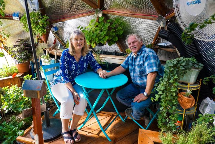 The Swanks in their custom garden greenhouse