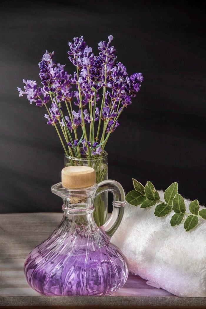 sprigs of lavender and a decanter filled with purple liquid Pixabay