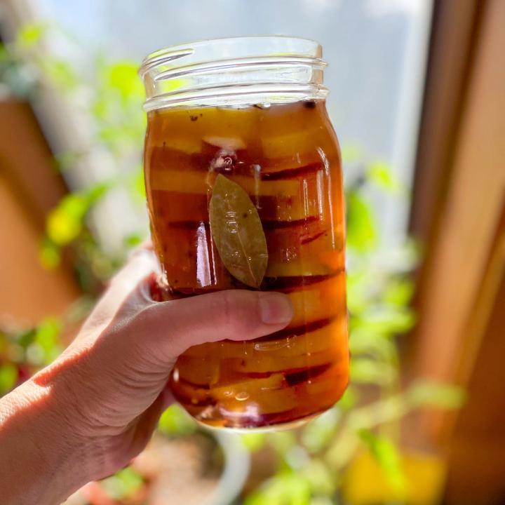 holding up finished jar of pickled beets