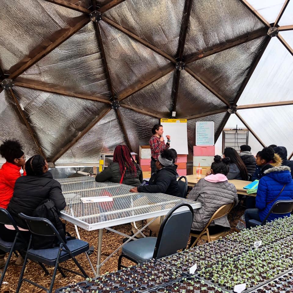 Class of students being instructed in a Growing Dome greenhouse