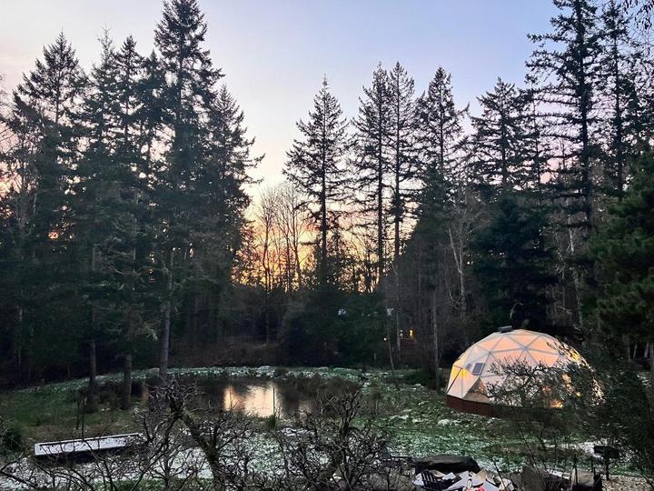 Serene lake, early light reflecting off the water and the Growing Dome
