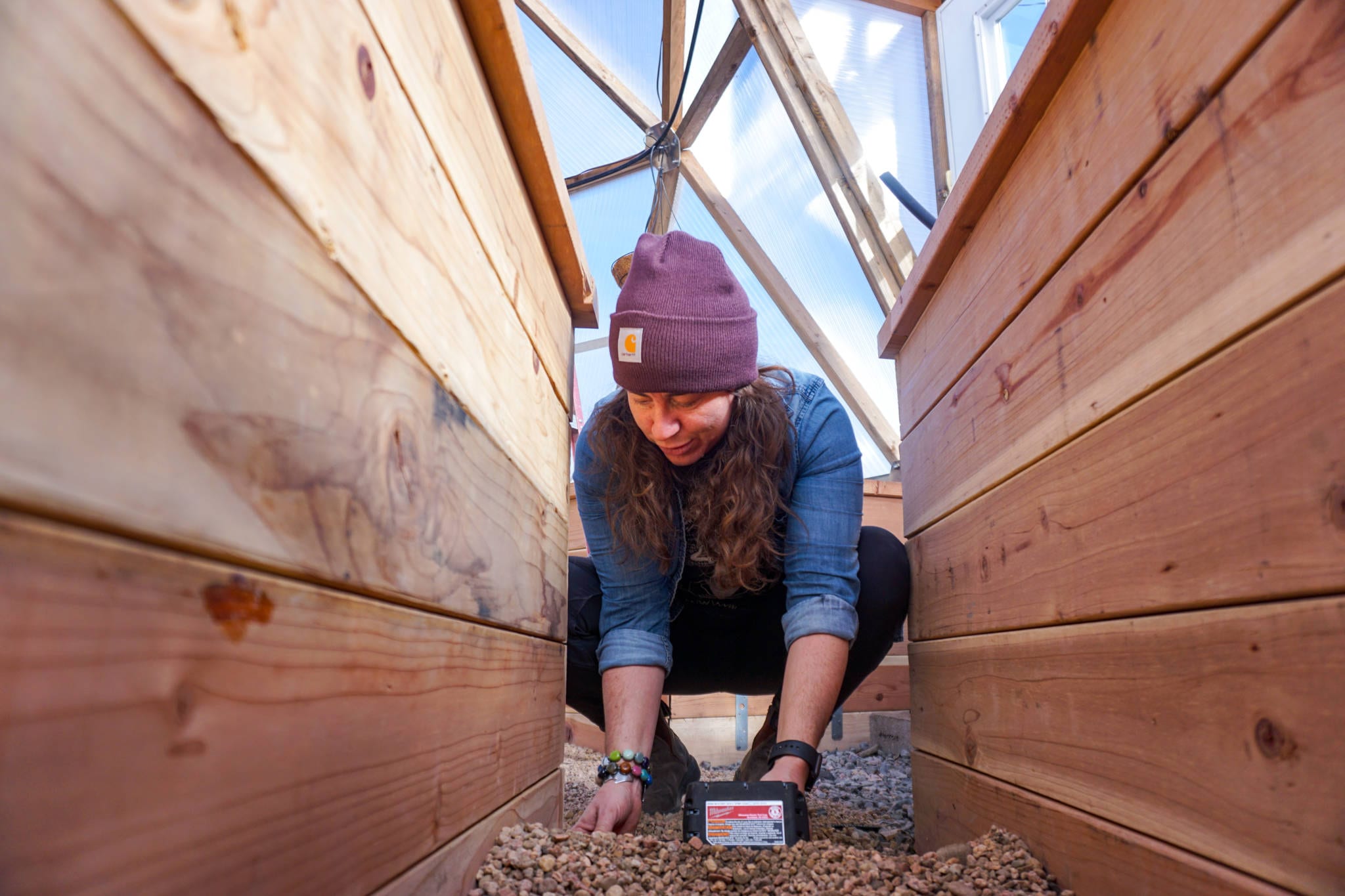 GoFarm Farmer Apprentice Shannon Harker installing a drip irrigation system in a Growing Dome