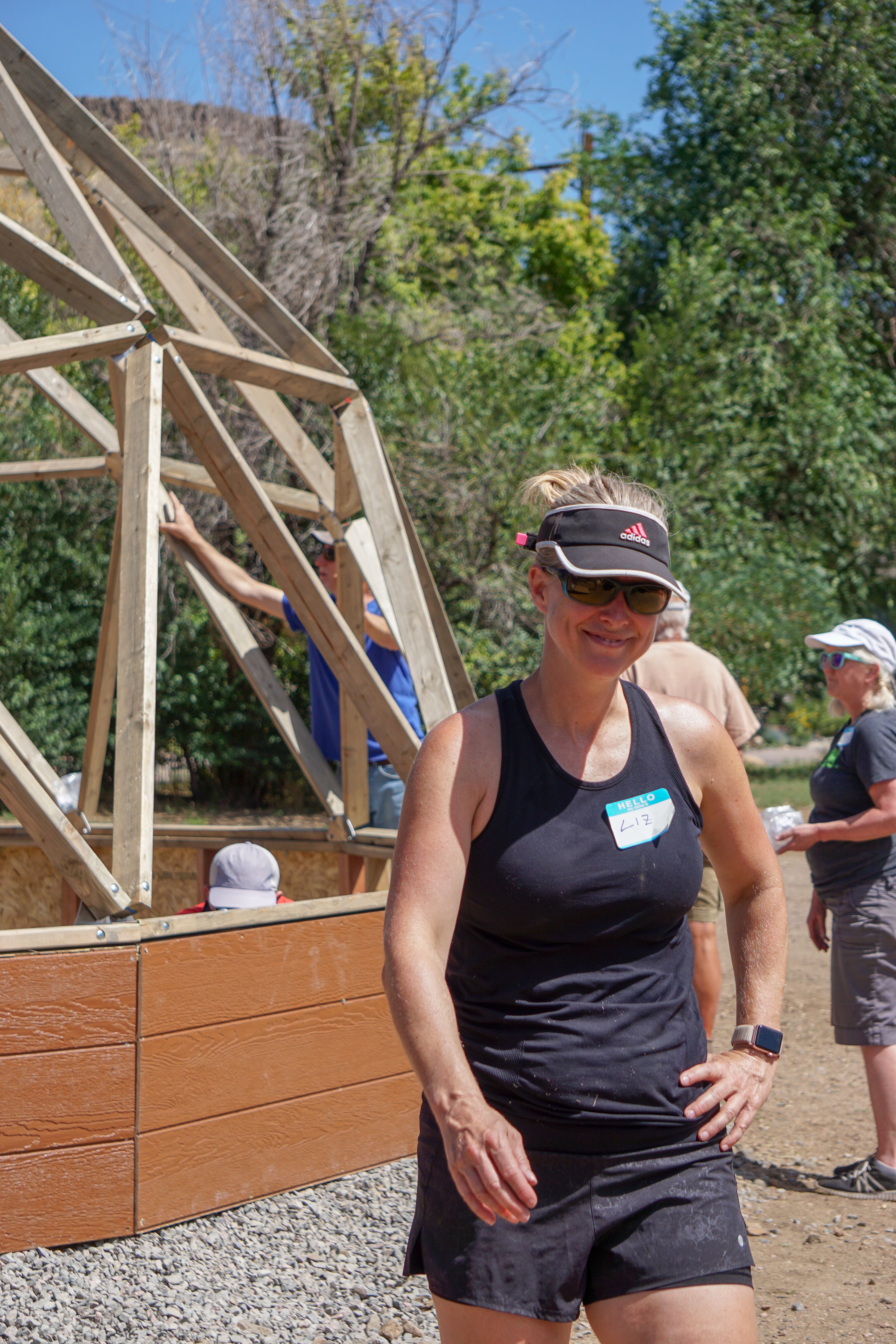Woman wearing a black tank top walking around a greenhouse construction site