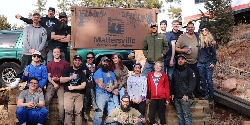 Group posing in front of a welcome sign
