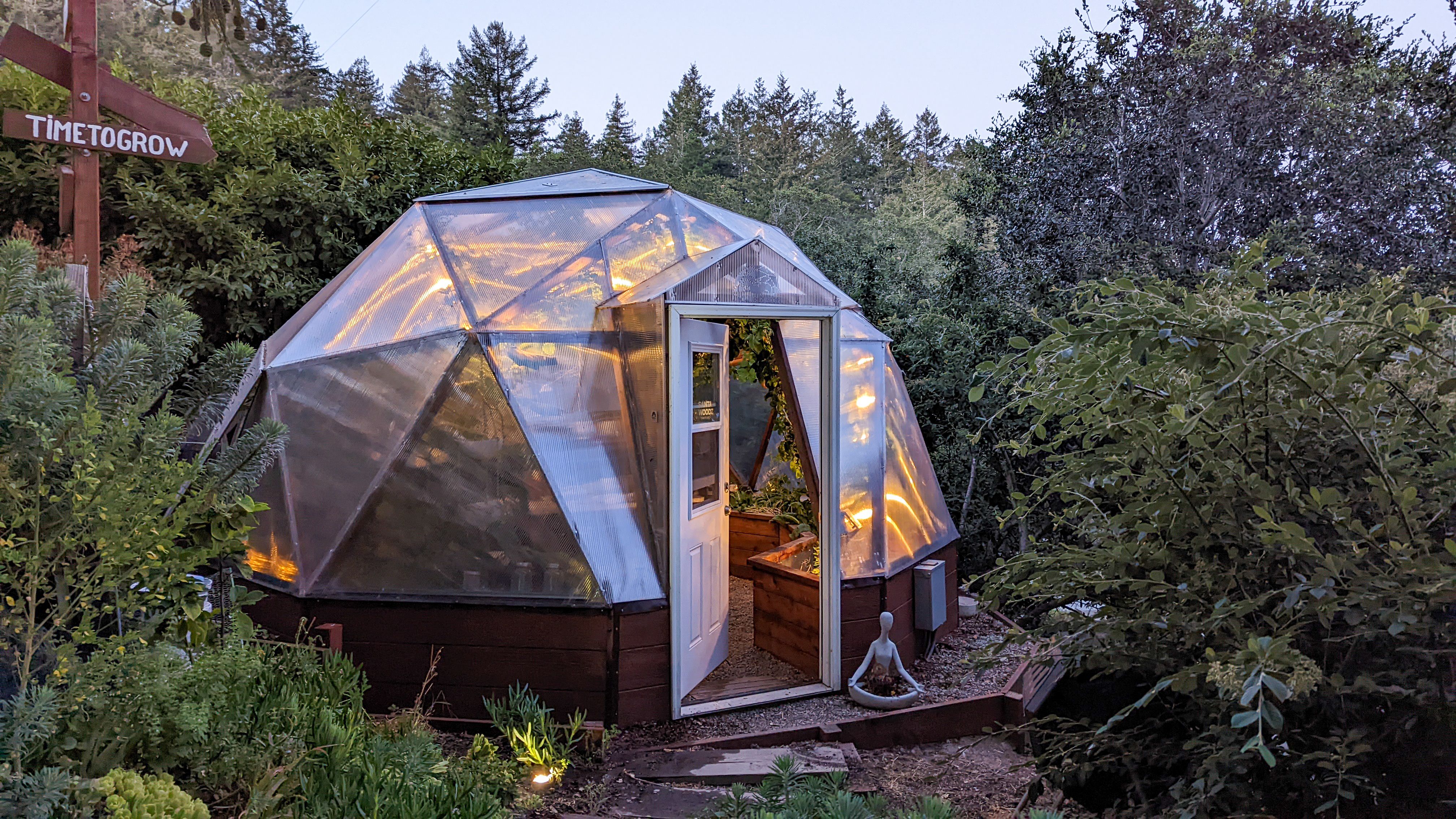18 foot diameter Growing Dome greenhouse illuminated with warm light at dusk