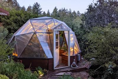 18 foot diameter Growing Dome greenhouse illuminated with warm light at dusk