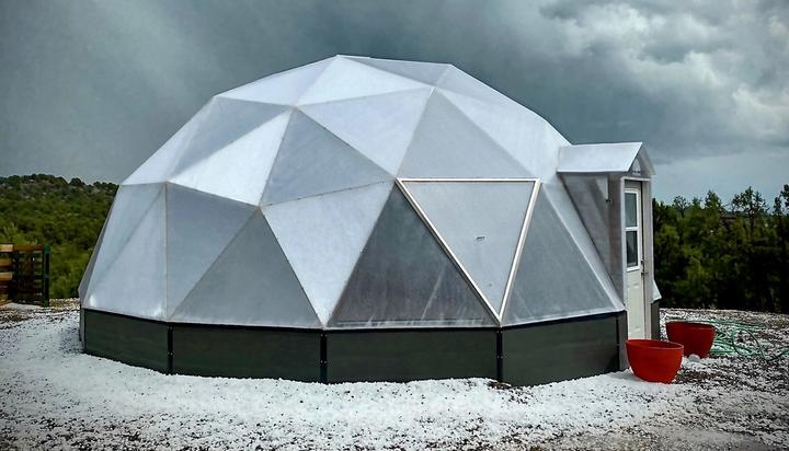 22 foot diameter growing dome surrounded by dark grey clouds with hail on ground