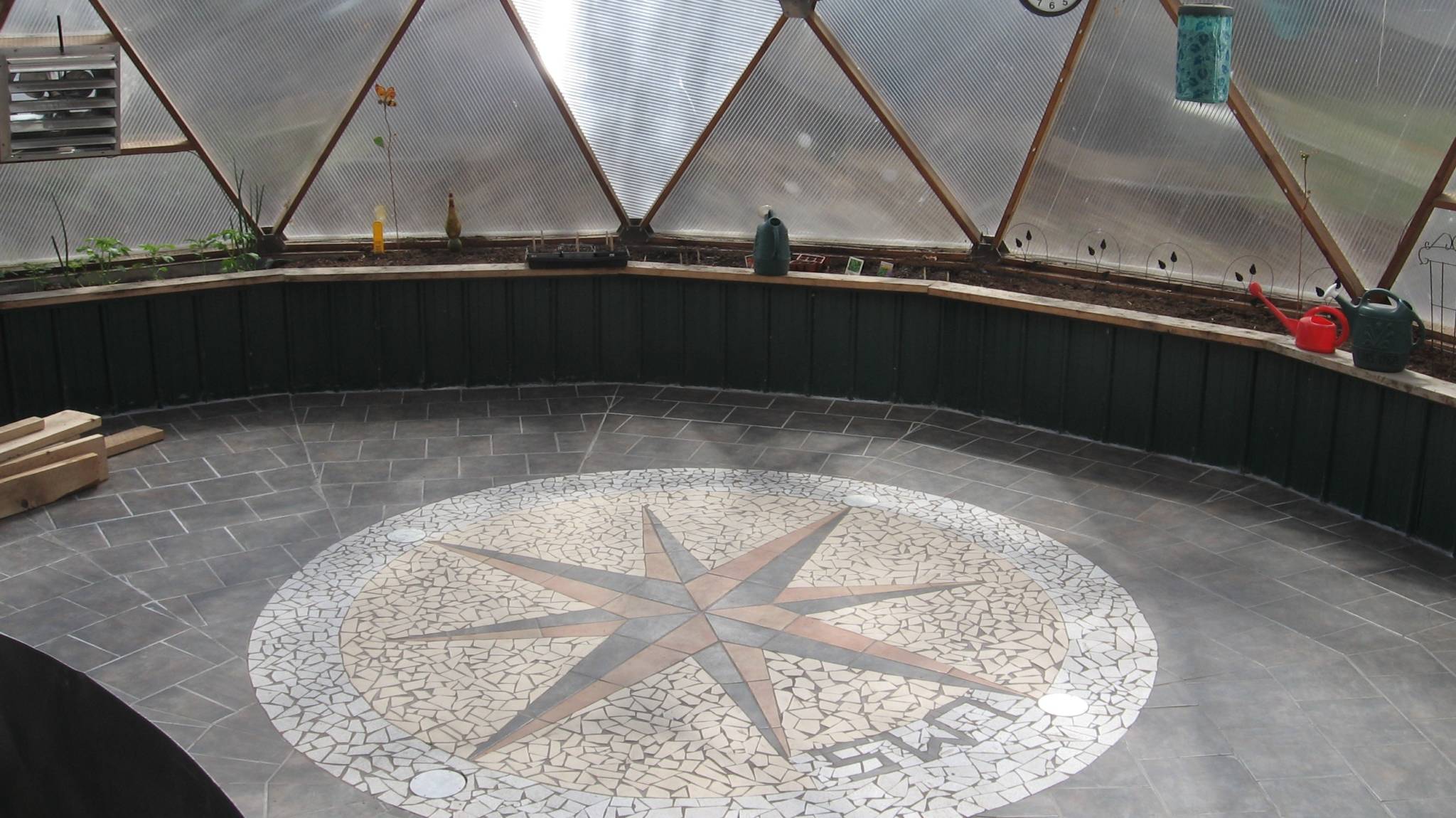 brick and mosaic flooring inside of geodesic greenhouse