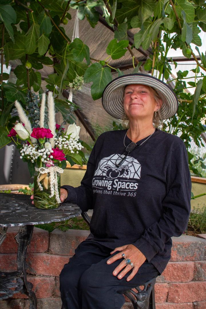 Woman in a straw hat posing for a phot with a bouquet