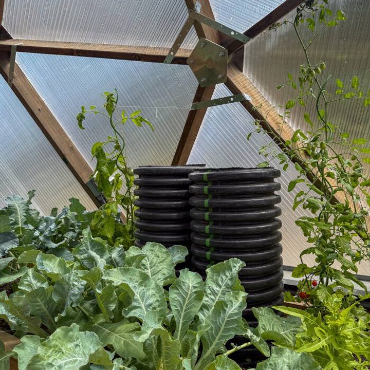 Large black corrugated outlet tubes for a greenhouse climate battery
