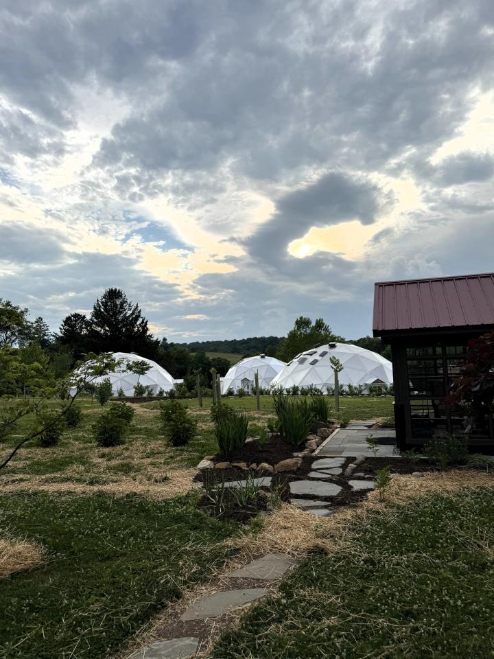 Three domes at Kula Kamala in the background as stone path leads to a building in foreground