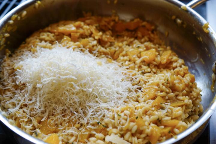 adding Parmesan cheese to pumpkin spice risotto
