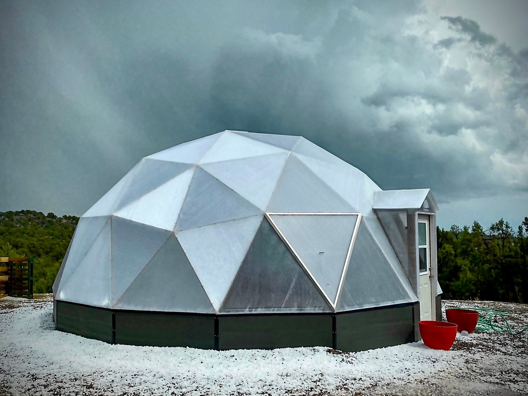 26 foot diameter growing dome greenhouse surrounded by hail and dark sky