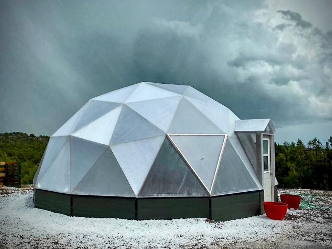 Growing Dome greenhouse surrounded by hail after a storm