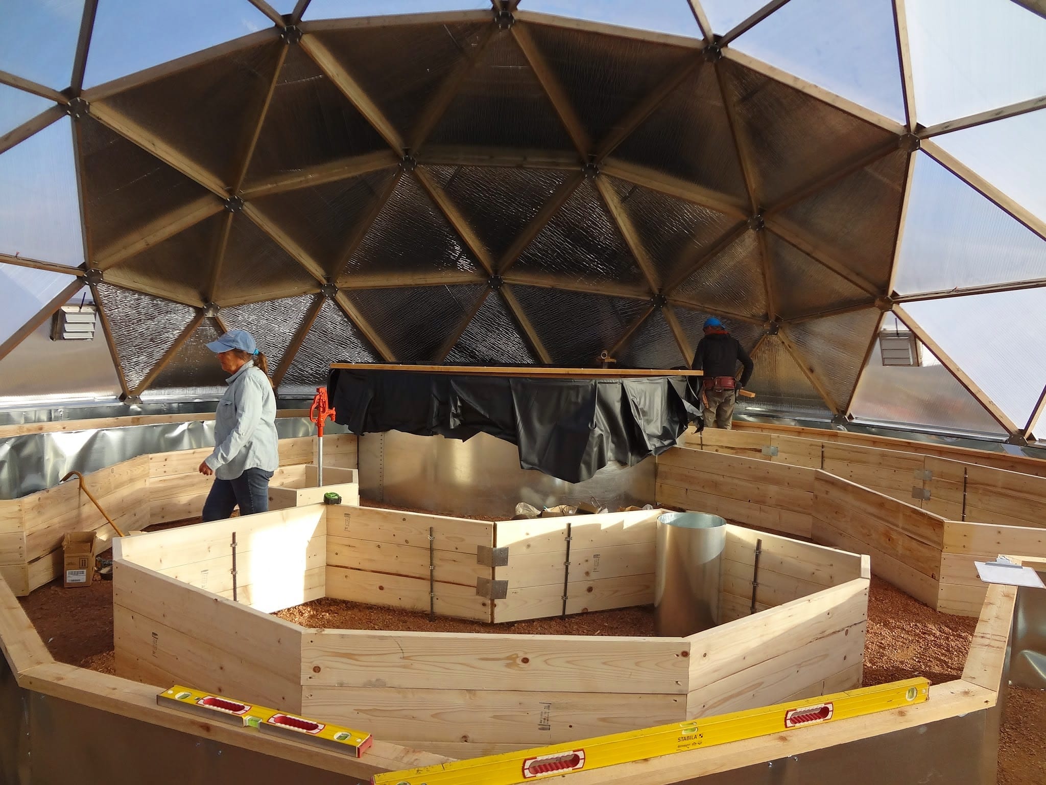 raised wooden garden beds going into a new geodesic greenhouse that haven't been filled with soild yet