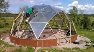Person attaching polycarbonate to a 26' Growing Dome
